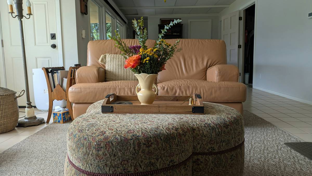storage tray ottoman with wooden top open to reveal neatly stacked serving trays inside